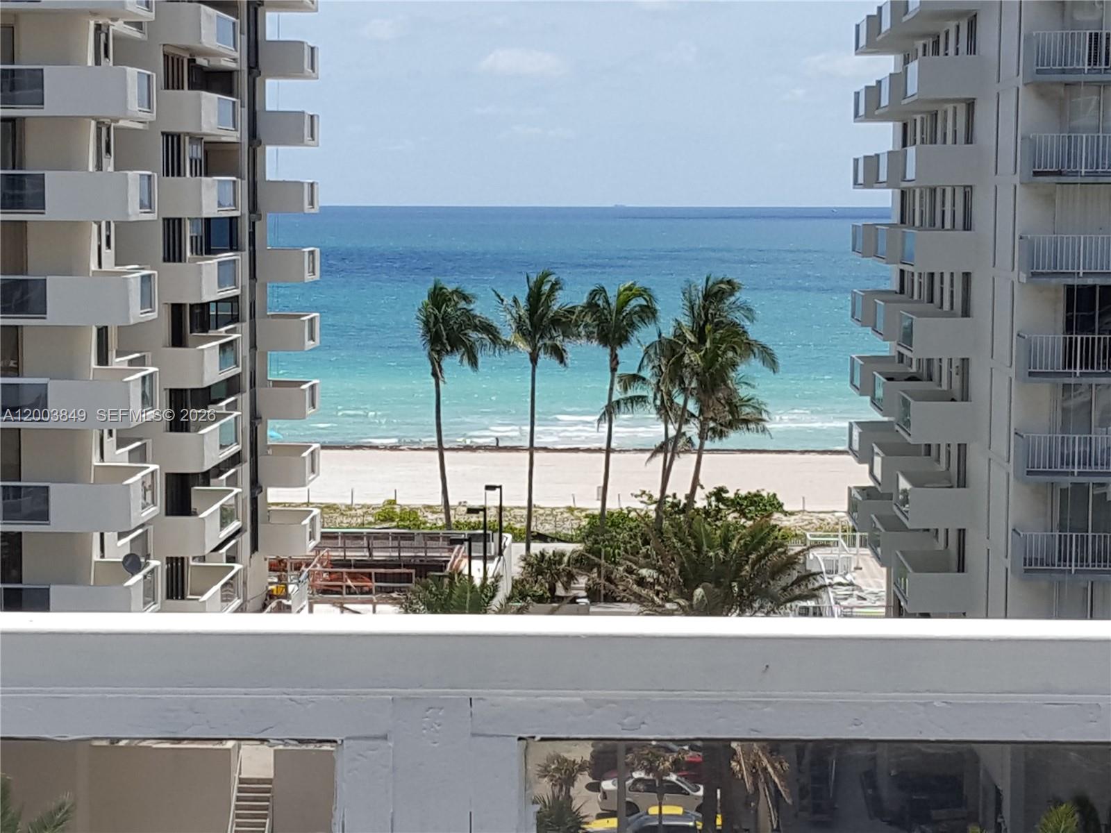 A view of the ocean and beach framed by two tall residential buildings — 5700 Collins Ave # 8A, Miami Beach FL 33140, MIAMI BEACH, FL