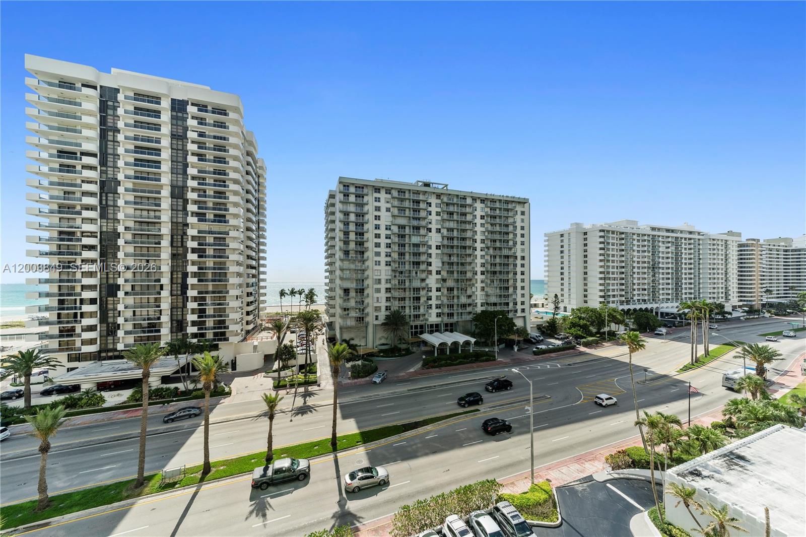 An elevated view shows several tall residential buildings along a coastal road with palm trees — 5700 Collins Ave # 8A, Miami Beach FL 33140, MIAMI BEACH, FL