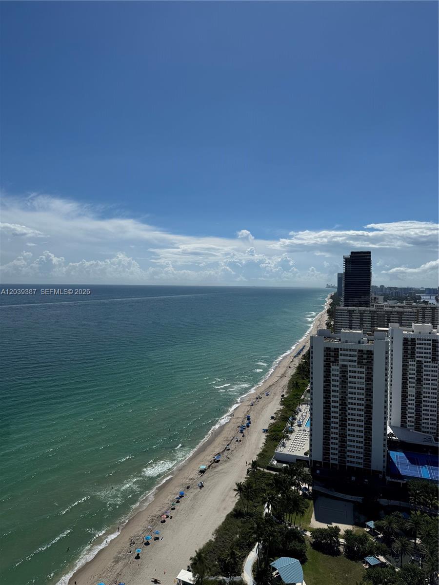 An elevated view of a sandy beach, ocean, and high-rise buildings under a blue sky — 1830 S Ocean Dr # 3303, Hallandale Beach FL 33009, HALLANDALE BEACH, FL
