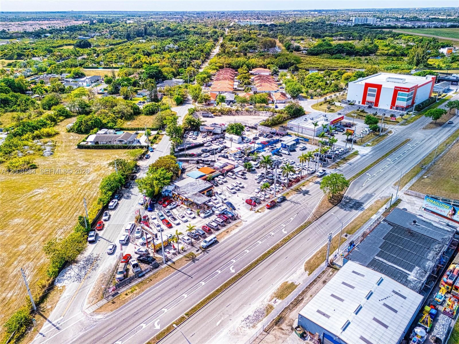 An aerial view shows a car dealership lot situated next to a multi-lane road — 22825 S Dixie Hwy, Miami FL 33170, MIAMI, FL