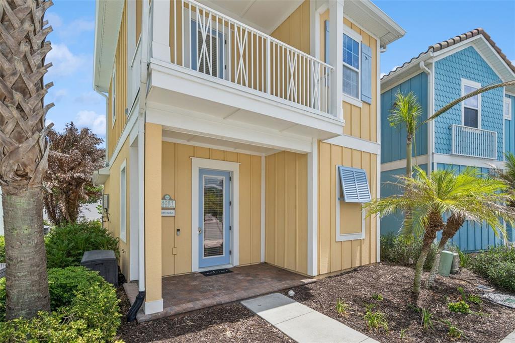 A yellow two-story house with a blue front door and a second-floor balcony — 8081 KNEE DEEP ROAD, KISSIMMEE, FL