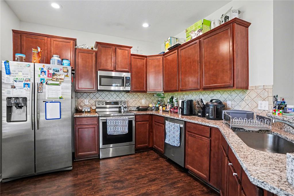 A living room features a white sectional sofa, glass coffee table, and dining area — 5520 KINGLETHILL DRIVE, LITHIA, FL
