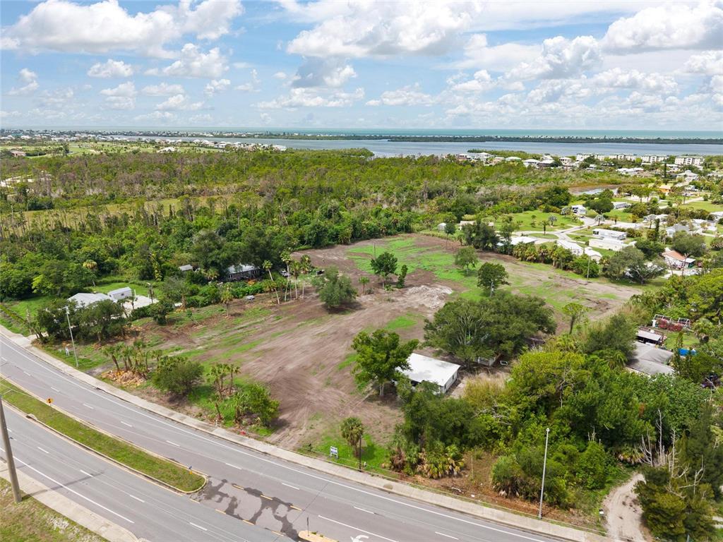 An aerial view shows a large, partially cleared vacant lot adjacent to a multi-lane road — 5230 PLACIDA ROAD, ENGLEWOOD, FL