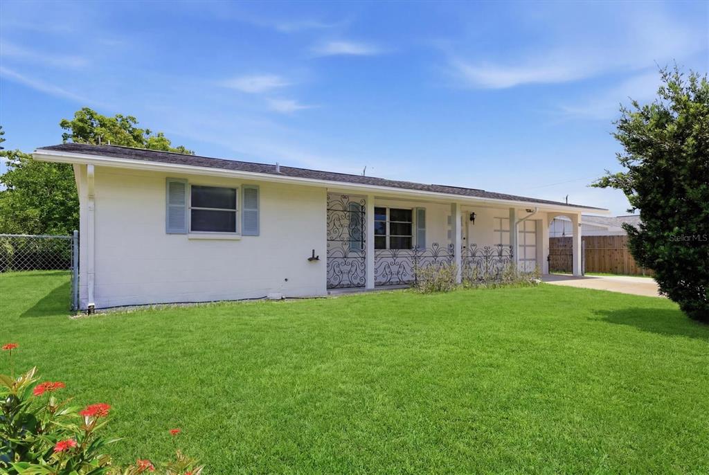 A single-story house with a white exterior, a front lawn, and decorative metal security doors — 329 SAN BENITO AVENUE, NORTH PORT, FL