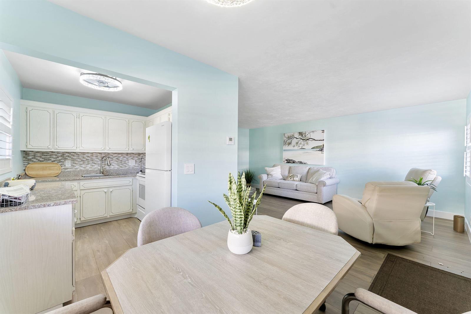 A dining area with a table and chairs opens into a kitchen and living room — 3322 Cynthia Lane # 102, FL 33461, FL