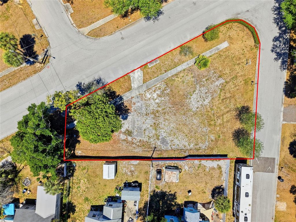 An aerial view shows a vacant, triangular-shaped corner lot outlined in red — 4716 IRIS STREET N, ST PETERSBURG, FL
