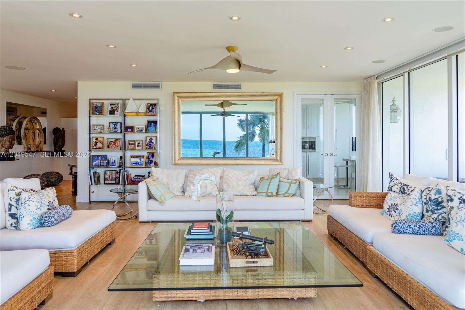 A living room features a white sofa, wicker-based seating, a glass coffee table, and ocean views — 200 Ocean Lane Dr # 501, Key Biscayne FL 33149, KEY BISCAYNE, FL