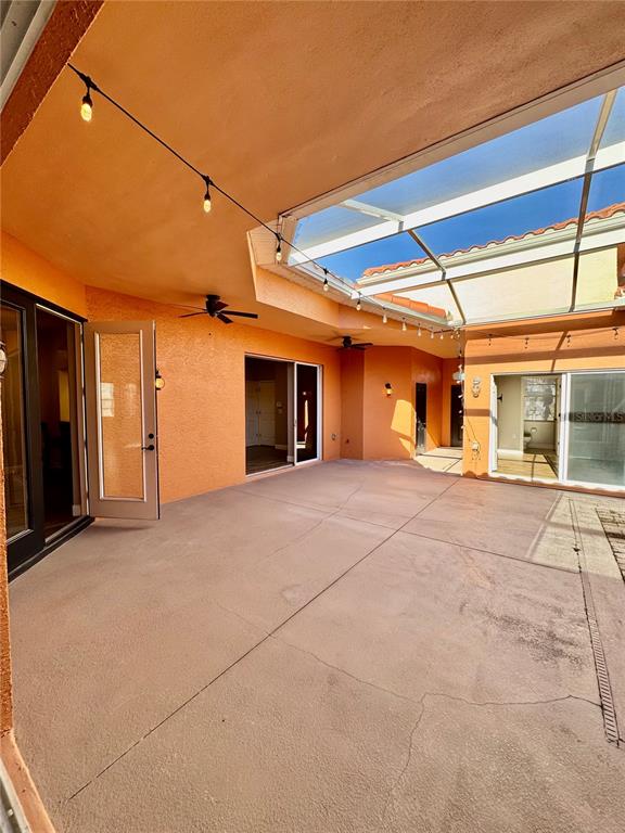 A covered outdoor patio with a concrete floor, ceiling fans, and a screened-in roof — 8636 VILLANOVA DRIVE UNIT 1201, CAPE CANAVERAL, FL