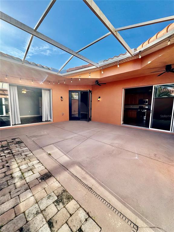 A screened-in patio features a concrete floor, brick pavers, and sliding glass doors — 8636 VILLANOVA DRIVE UNIT 1201, CAPE CANAVERAL, FL