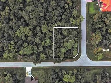This aerial view shows a vacant, wooded residential lot outlined in white at a street corner — 145 LOFTIN STREET, PORT CHARLOTTE, FL