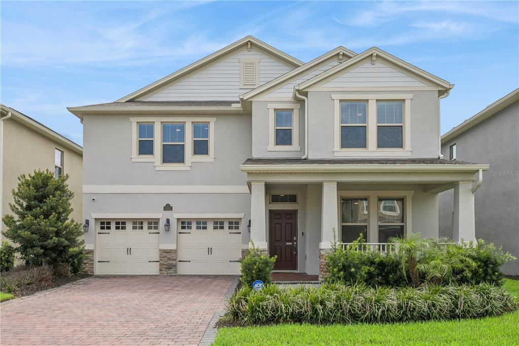 A two-story suburban house with a two-car garage and a covered front porch — 11031 JACKSON COVE, WINTER GARDEN, FL