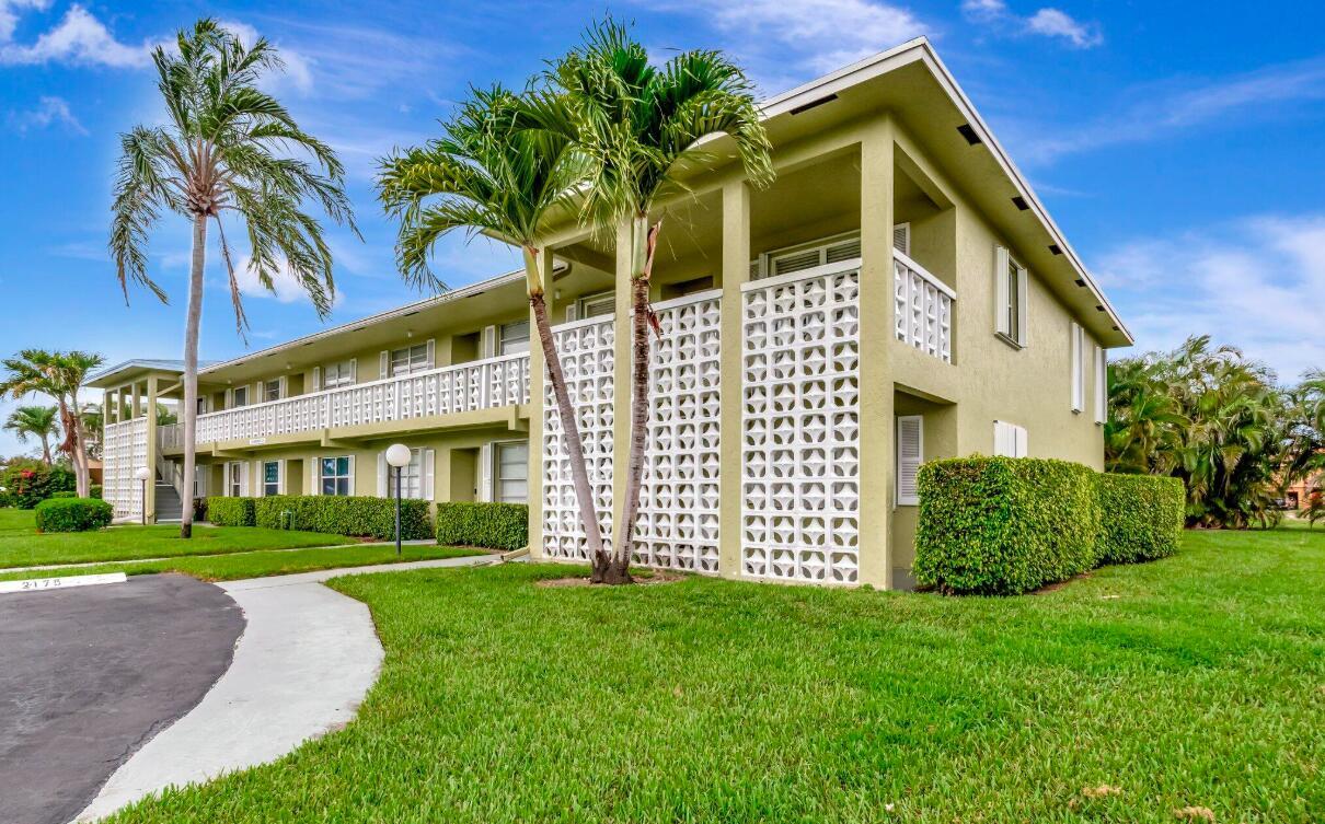 A two-story apartment building with a green exterior, palm trees, and decorative concrete block screens — 1140 Mahogany Way # 204, Delray Beach FL 33445, DELRAY BEACH, FL