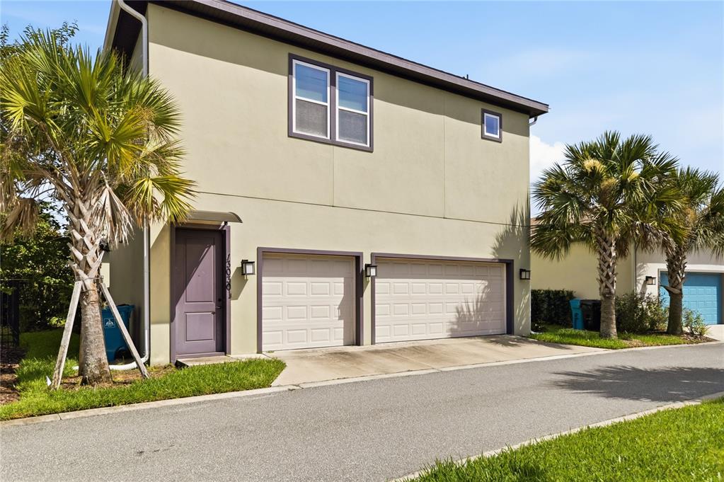 A two-story house exterior features a purple door, two garage doors, and palm trees — 13030 STODDART AVENUE, ORLANDO, FL
