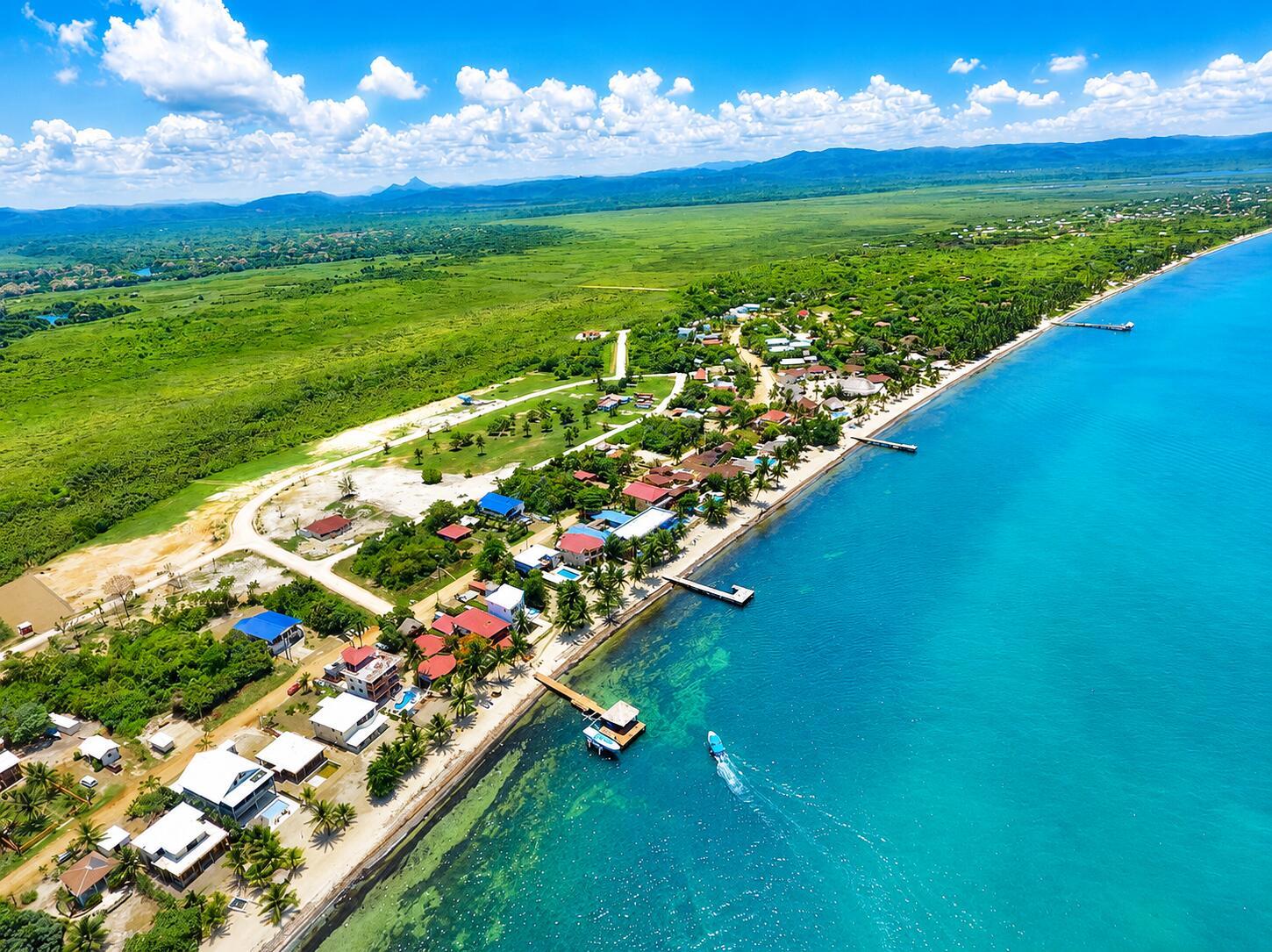 Aerial view of a coastal village with houses, docks, and a boat on turquoise water — Lot 37 Sittee River Road Lot 37, FL