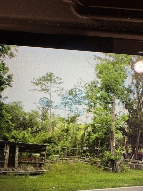 A wooden shed stands in a grassy, wooded lot with a wire fence — COUNTY ROAD 305, BUNNELL, FL