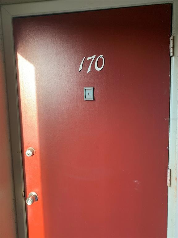 A red apartment door features the number 170, a peephole, and two silver-toned locks — 1799 N HIGHLAND AVENUE UNIT 170, CLEARWATER, FL