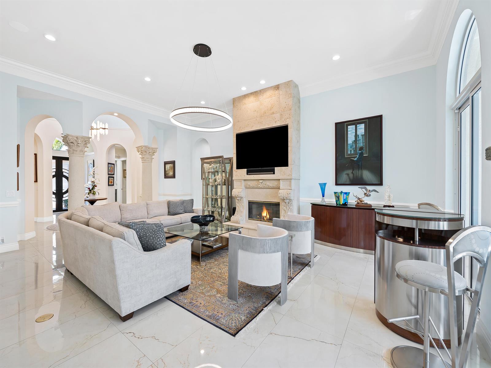 A living room features a fireplace, a large sectional sofa, and a curved bar area — 2370 Deer Creek Trail, Deerfield Beach FL 33442, DEERFIELD BEACH, FL
