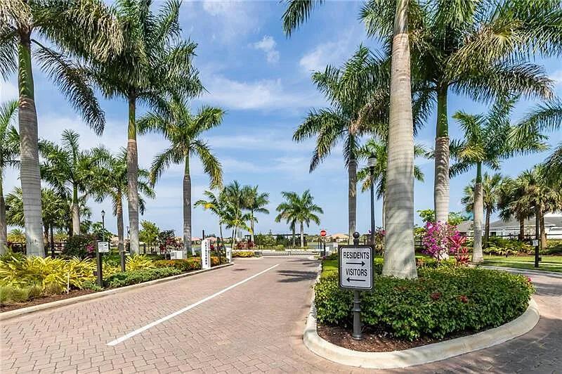A paved entrance road leads through a gated community lined with tall palm trees — 5716 S Sterling Ranch, Davie FL 33314, DAVIE, FL