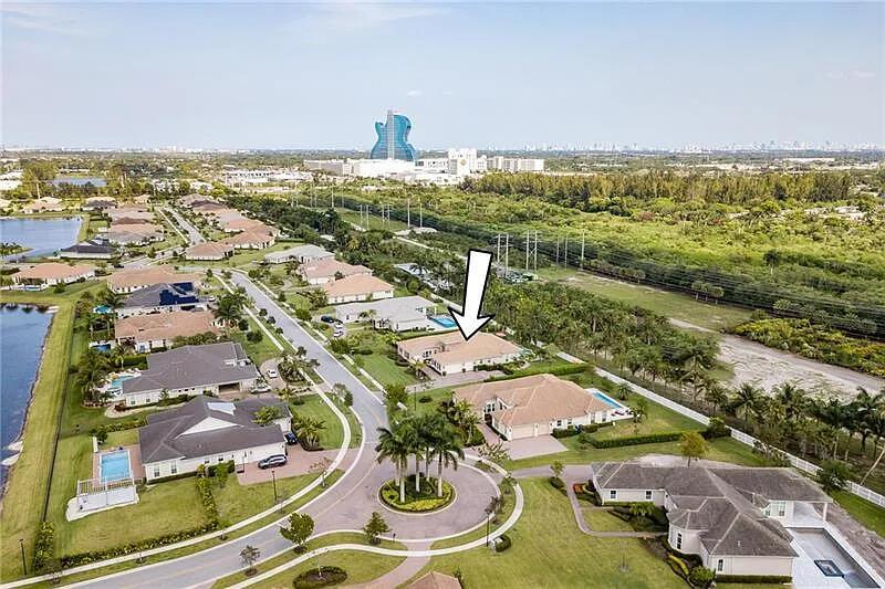 An aerial view shows a suburban residential neighborhood with a large guitar-shaped building nearby — 5716 S Sterling Ranch, Davie FL 33314, DAVIE, FL