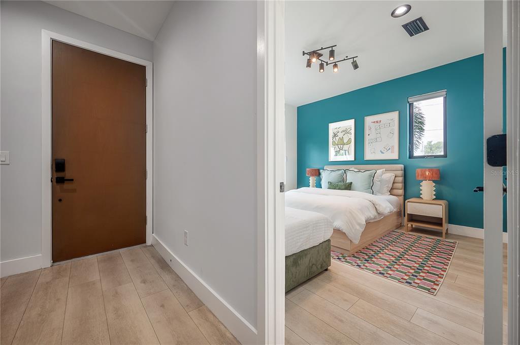 A view from a hallway into a bedroom with a teal accent wall and bed — 117 W GLADYS STREET UNIT 2, TAMPA, FL