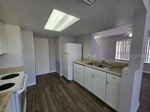 A kitchen with white cabinets, a white refrigerator, a dishwasher, and wood-look flooring — 103 COCONUT PALM WAY, DAVENPORT, FL