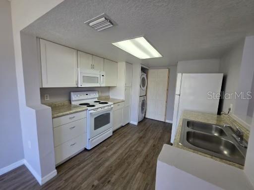 A kitchen features white cabinets, stainless steel appliances, a double sink, and wood-look flooring — 103 COCONUT PALM WAY, DAVENPORT, FL