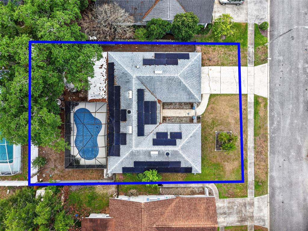 An aerial view shows a house with a pool enclosure and solar panels on the roof — 3217 LAKE ANDERSON AVENUE, ORLANDO, FL
