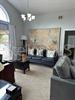 A living room features a dark sofa, a large wall map, and a chandelier — 2986 STILLWATER DRIVE, KISSIMMEE, FL