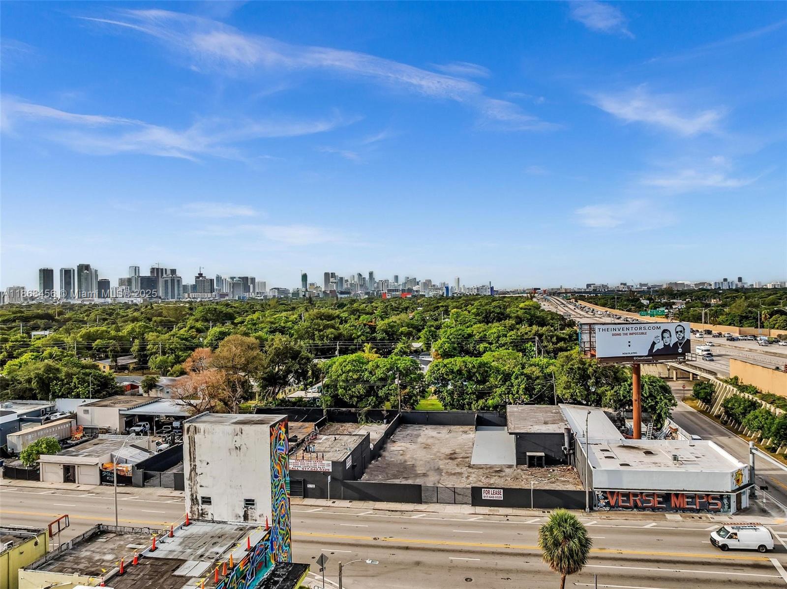 An elevated view shows a city skyline, a highway, and a commercial lot with graffiti — 570 NW 54th St, Miami FL 33127, MIAMI, FL