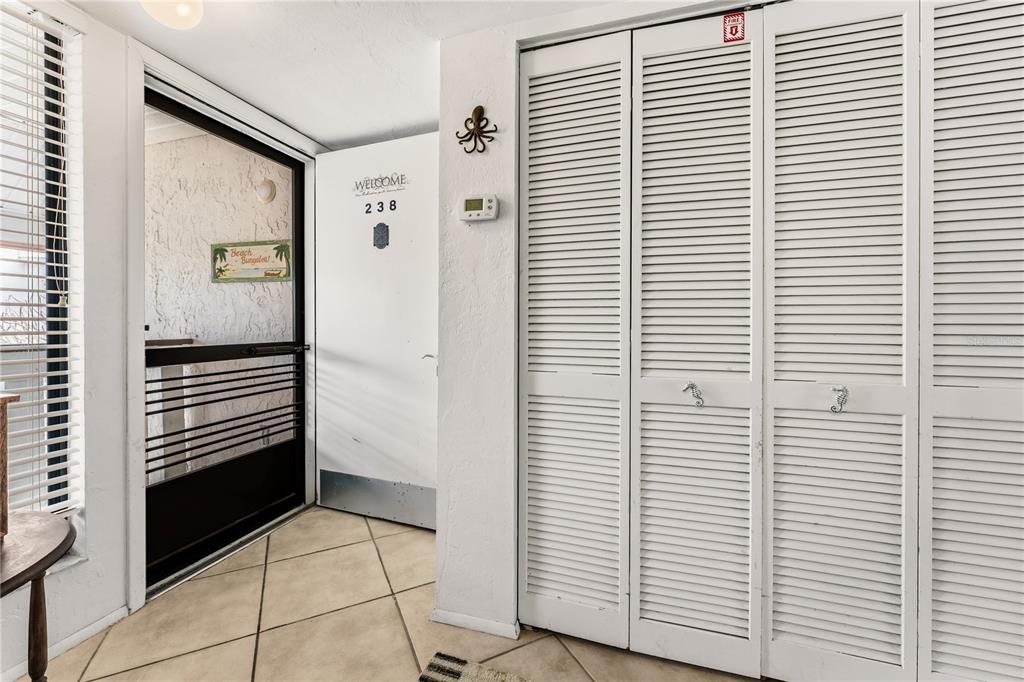 A tiled entryway features a white door labeled 238, louvered closet doors, and a screen door — 1801 GULF DRIVE N UNIT 238, BRADENTON BEACH, FL