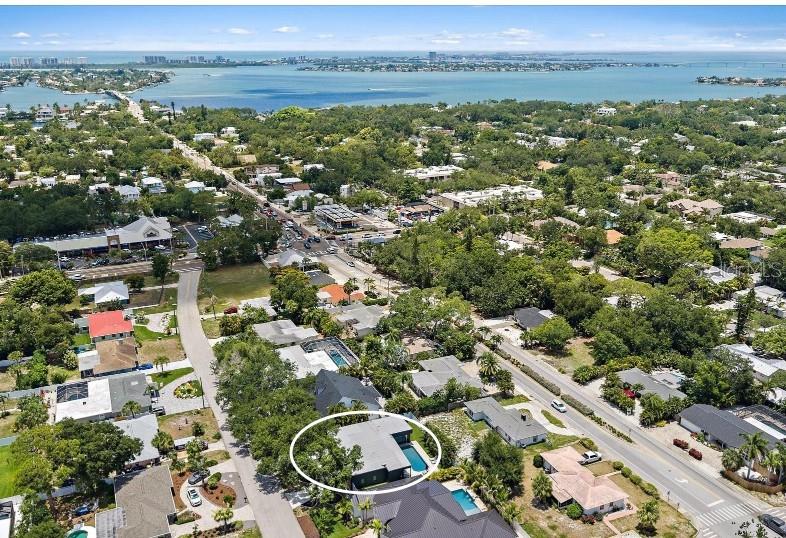 An aerial view shows a residential neighborhood with a highlighted house featuring a swimming pool — 1905 TULIP DRIVE, SARASOTA, FL