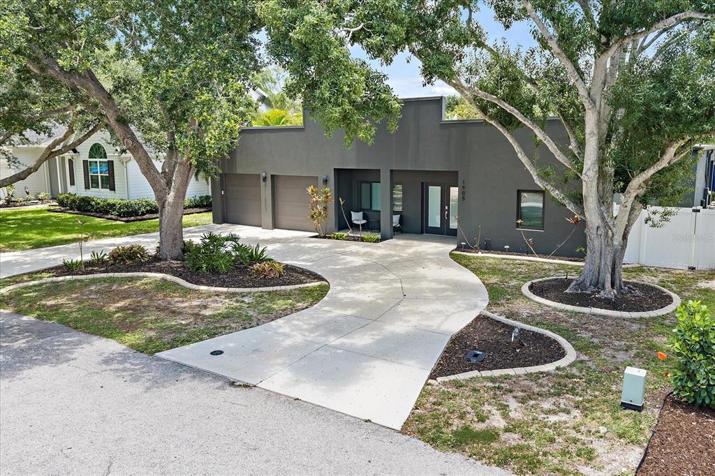 A modern gray house with a two-car garage and a curved concrete driveway — 1905 TULIP DRIVE, SARASOTA, FL