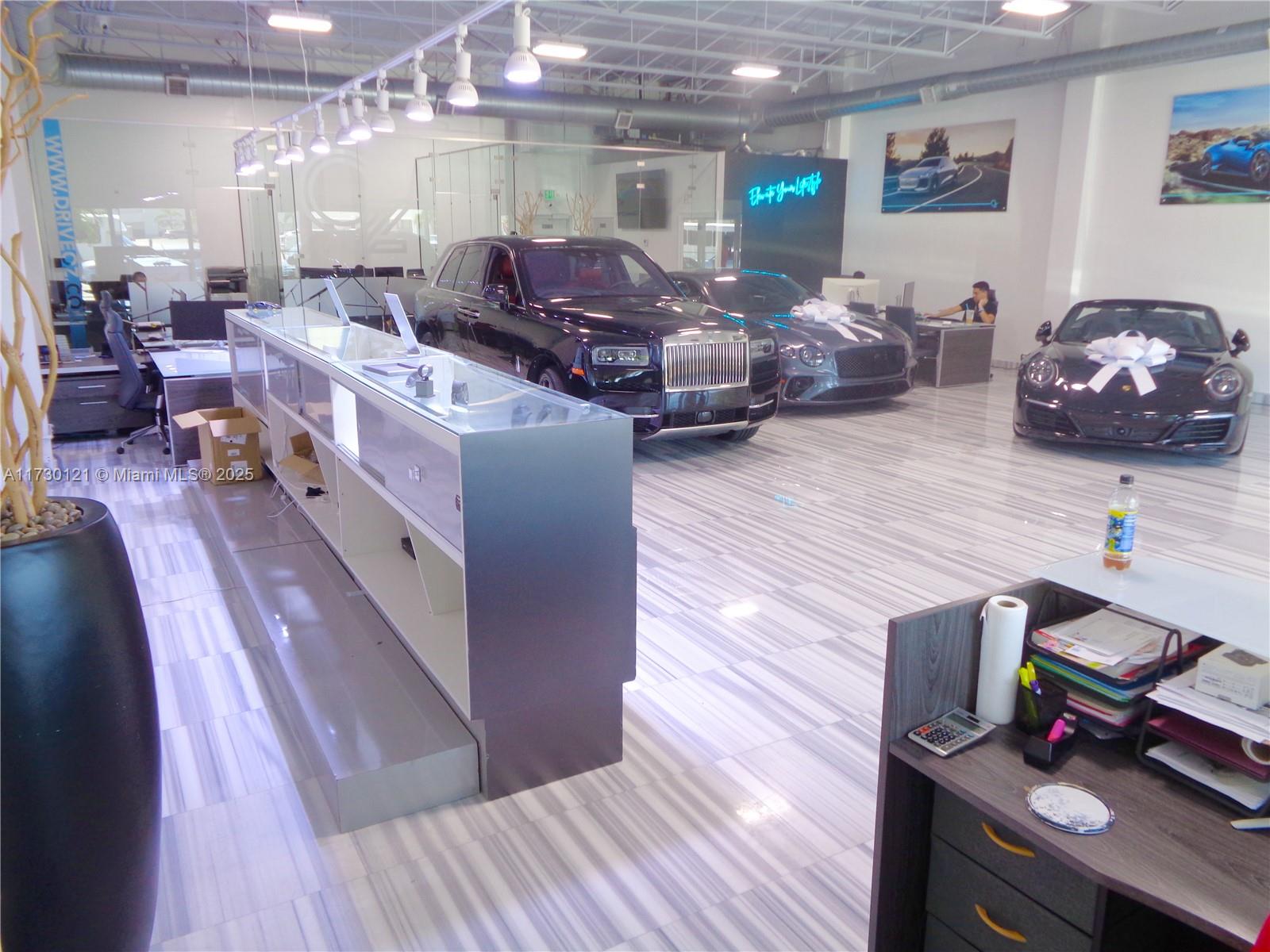A car dealership showroom features luxury vehicles, a long display counter, and tiled flooring — 3749 N Federal Hwy, Pompano Beach FL 33064, POMPANO BEACH, FL