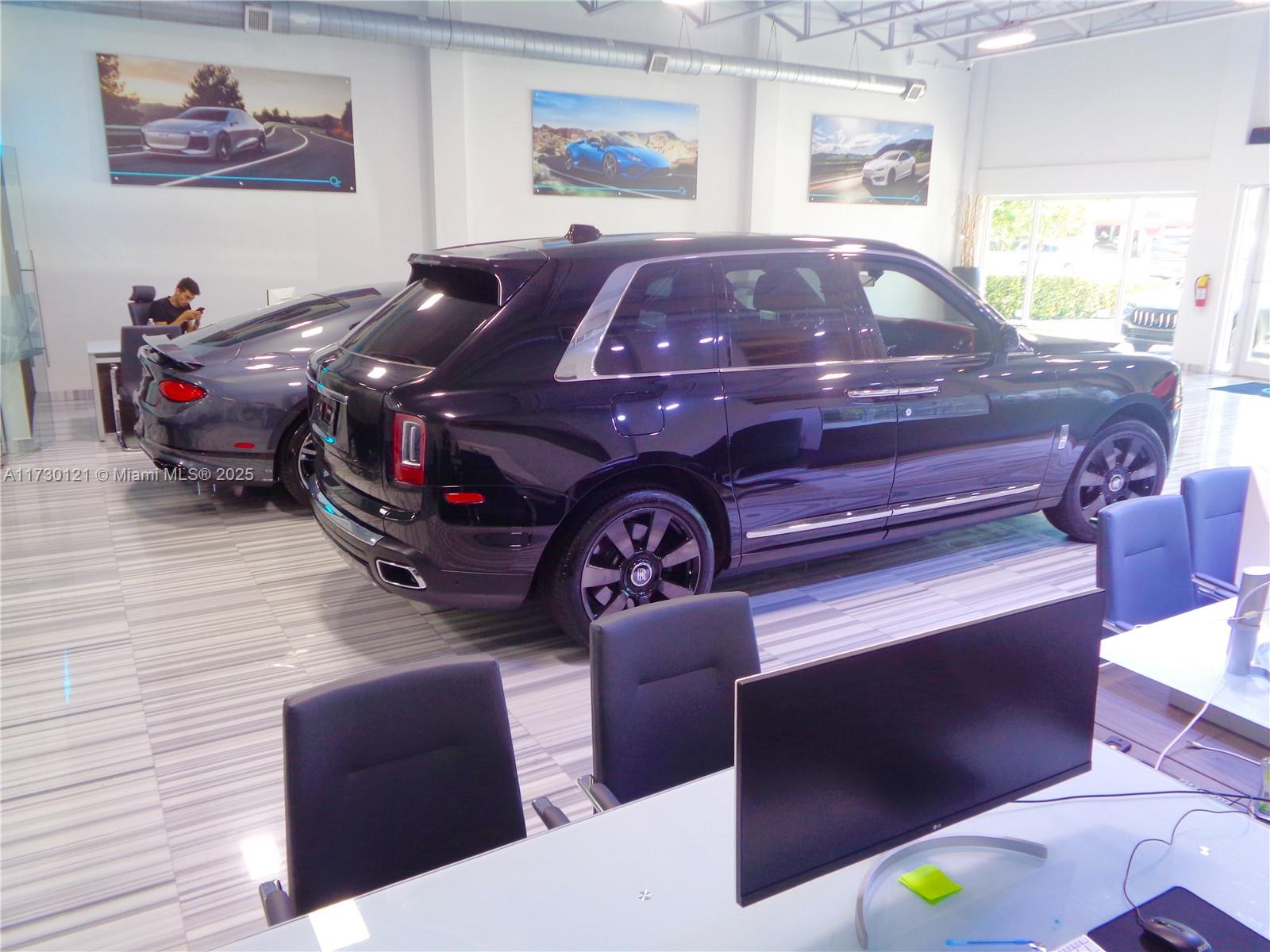 A car dealership showroom features a black SUV, a grey sports car, and office workstations — 3749 N Federal Hwy, Pompano Beach FL 33064, POMPANO BEACH, FL