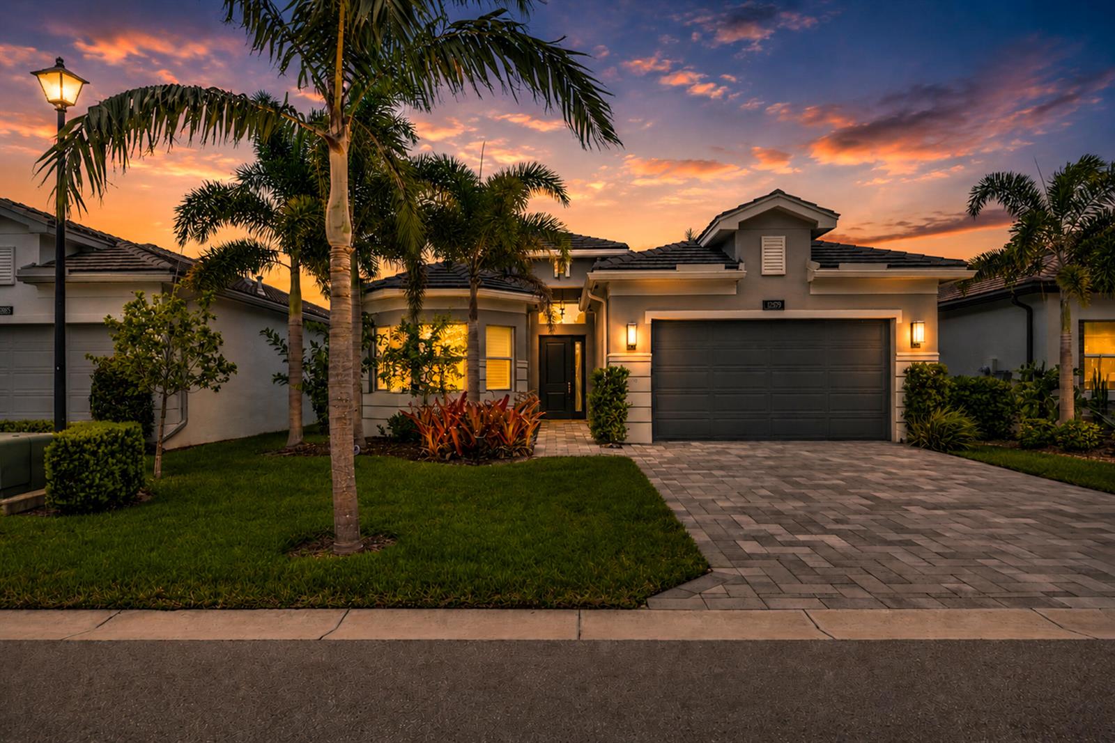A single-story house with a gray garage, paved driveway, and palm trees in the front yard — 12879 Parrot Pond Road, Boynton Beach FL 33473, BOYNTON BEACH, FL