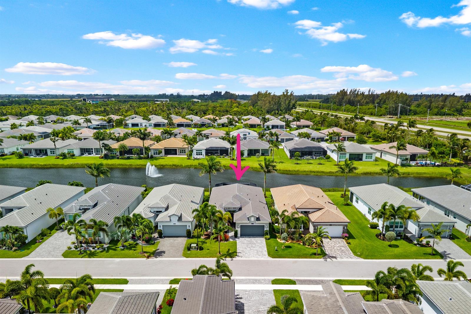 A single-story house with a paved driveway, palm trees, and a garage at sunset — 12879 Parrot Pond Road, Boynton Beach FL 33473, BOYNTON BEACH, FL