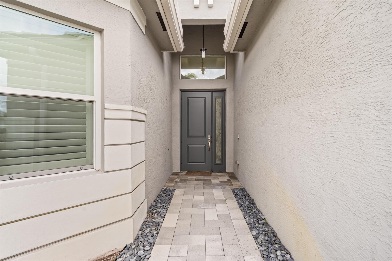 A stone water feature with the text Valencia Sound sits in a manicured lawn — 12879 Parrot Pond Road, Boynton Beach FL 33473, BOYNTON BEACH, FL