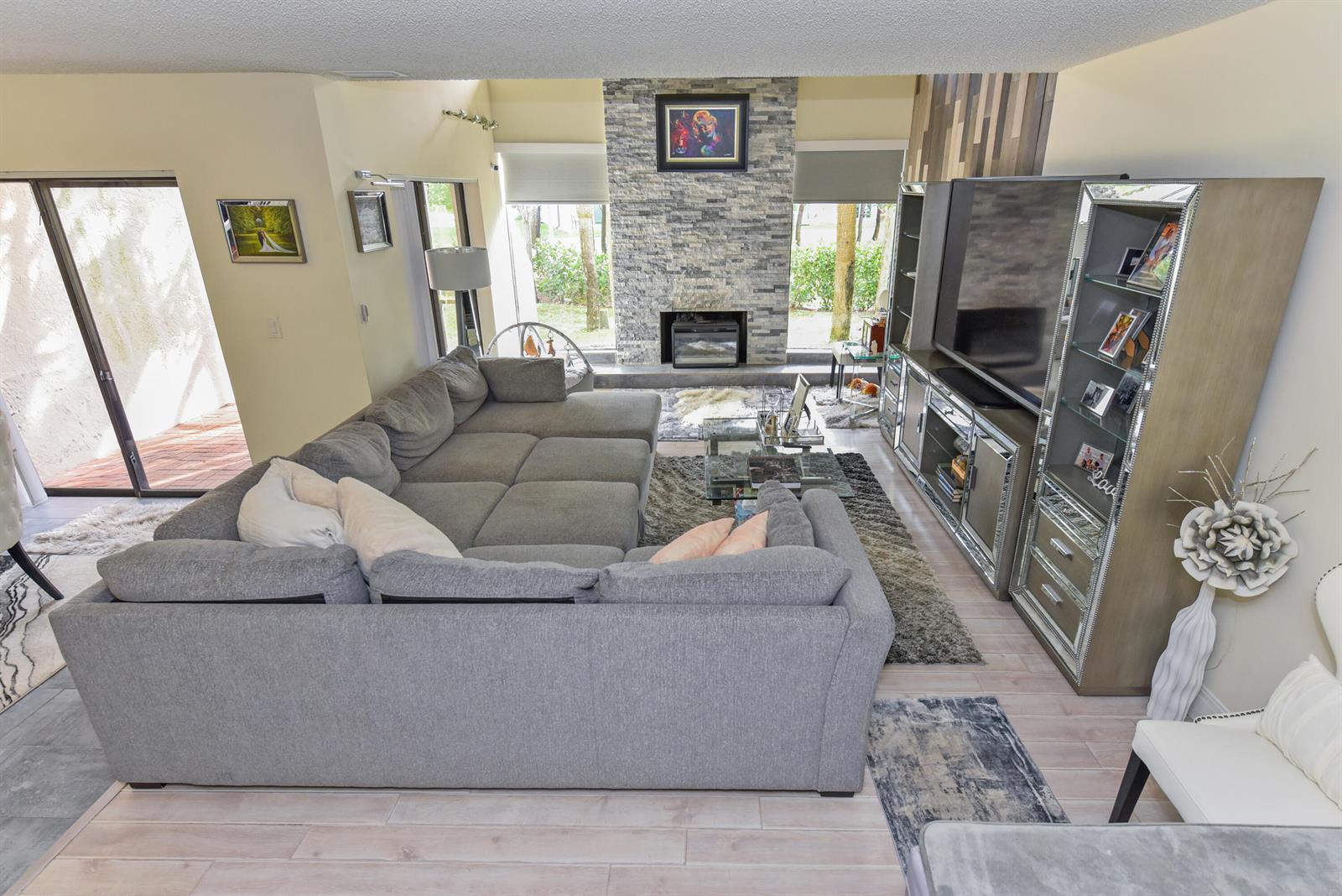 A dining area features grey tile flooring, a modern chandelier, and a sliding glass door — 22904 Ironwedge Drive, Boca Raton FL 33433, BOCA RATON, FL