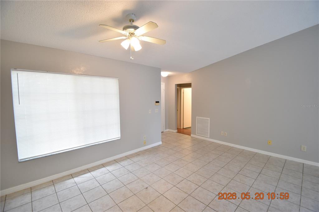 A living room with light gray walls, white tile flooring, and a ceiling fan — 12116 FELDWOOD CREEK LANE, RIVERVIEW, FL