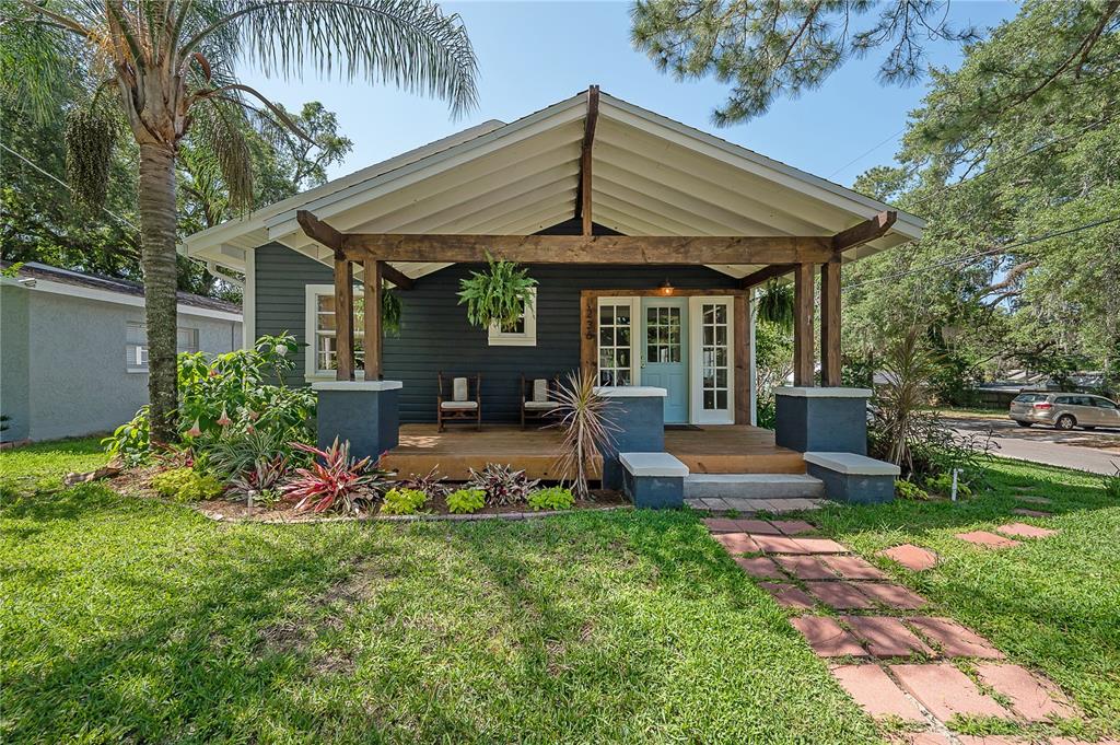 A dark gray bungalow with a wooden porch, pergola, and a light blue front door — 236 W NORTH STREET, TAMPA, FL