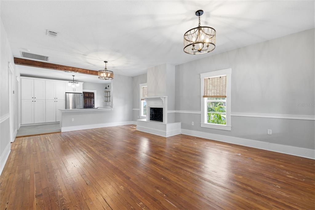 A living room with hardwood floors, a fireplace, and an open kitchen in the background — 236 W NORTH STREET, TAMPA, FL