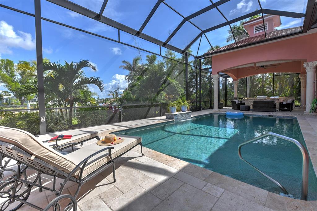 A screened-in pool area features a lounge chair, patio furniture, and tropical landscaping — 4409 CREWS COURT, PORT CHARLOTTE, FL