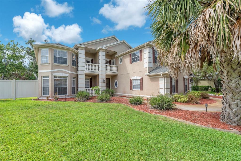 A two-story beige stucco house features a covered front entryway with a second-story balcony — 8805 CROSS LANDING LANE, RIVERVIEW, FL
