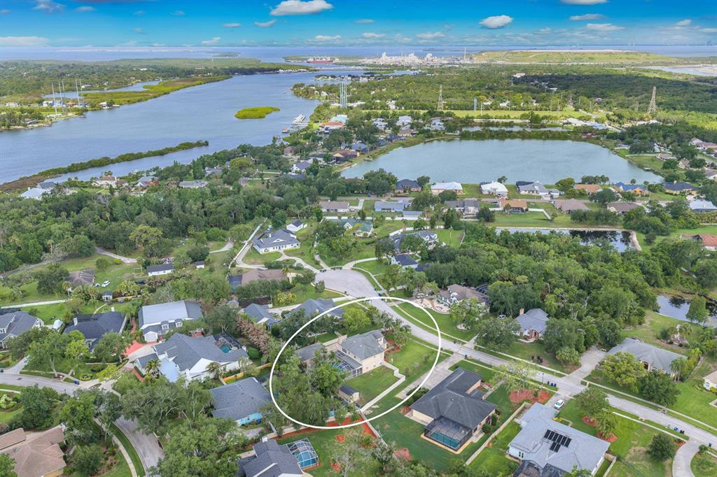 An aerial view shows a residential house with a pool enclosure in a suburban neighborhood — 8805 CROSS LANDING LANE, RIVERVIEW, FL