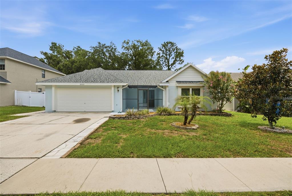 A light blue single-story house with a two-car garage and a screened front entryway — 2023 DARLINGTON OAK DRIVE, SEFFNER, FL