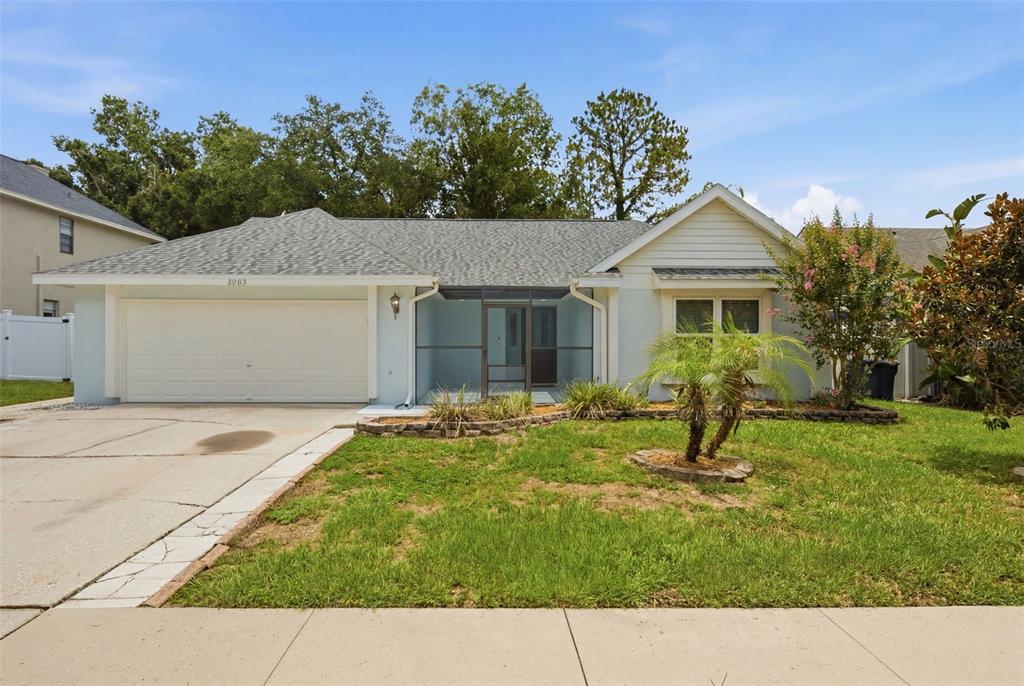 A single-story house with a light blue exterior, a two-car garage, and a screened entryway — 2023 DARLINGTON OAK DRIVE, SEFFNER, FL