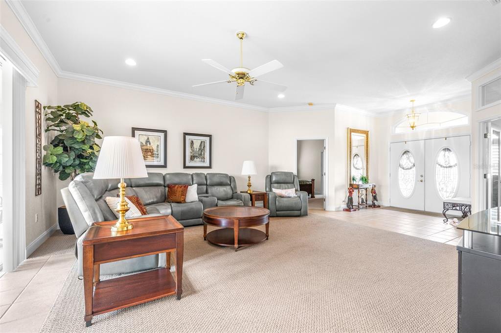 A living room features a grey sectional sofa, a round coffee table, and a ceiling fan — 6758 HUNTINGTON HILLS BOULEVARD, LAKELAND, FL