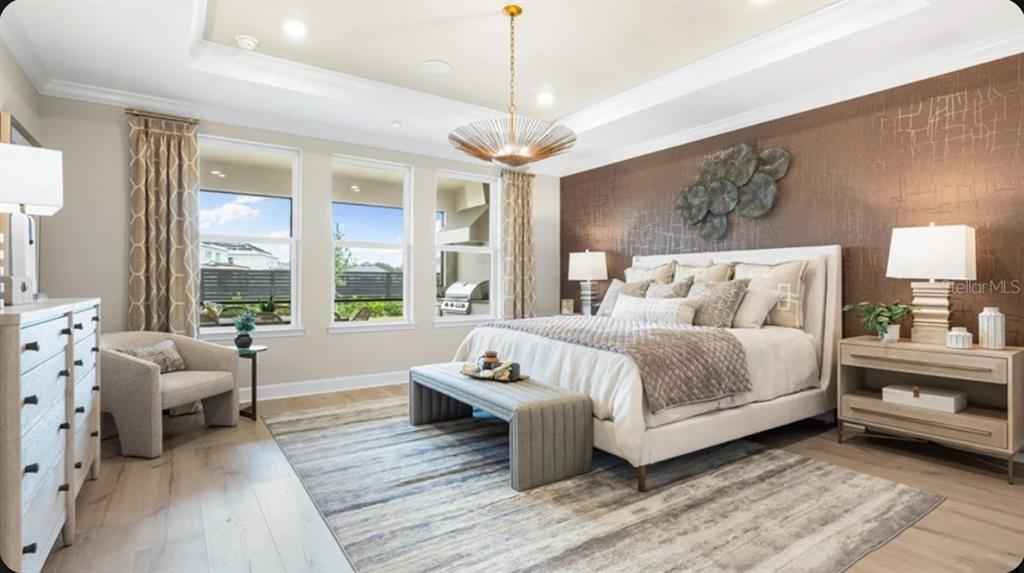 A bedroom features a king bed, textured brown accent wall, and a large area rug — 12517 WHARF TERRACE, PALMETTO, FL