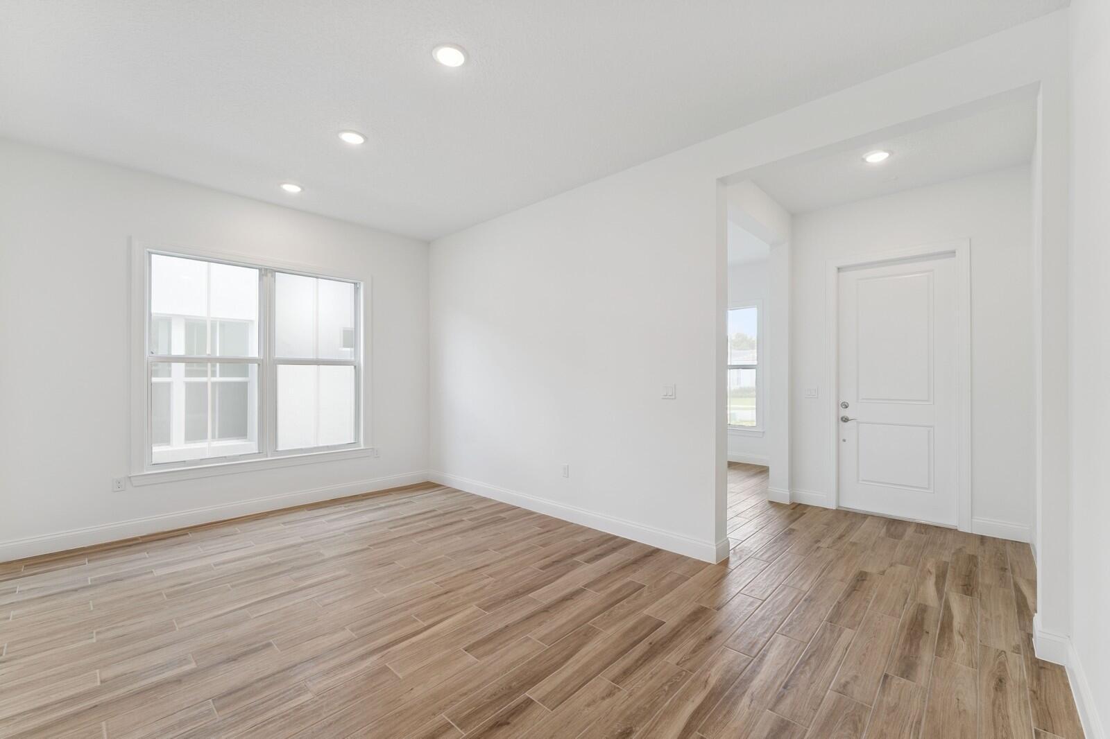 An empty room with white walls, recessed lighting, and wood-look tile flooring — 6799 SE Lost Pine Drive, Stuart FL 34997, STUART, FL