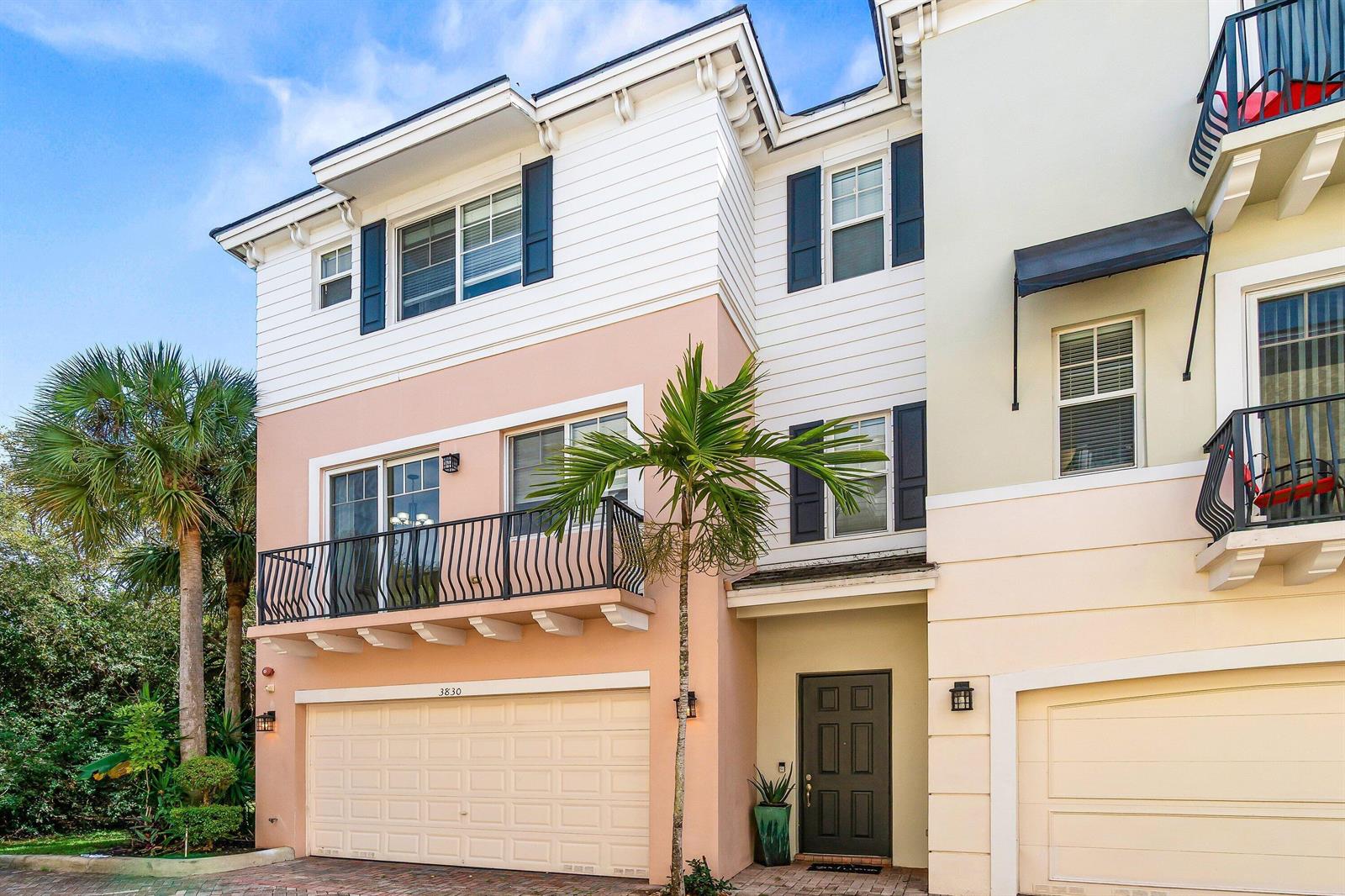 A three-story townhouse exterior features a peach-colored lower level, white siding, and a balcony — 3830 NW 5th Terrace, Boca Raton FL 33431, BOCA RATON, FL